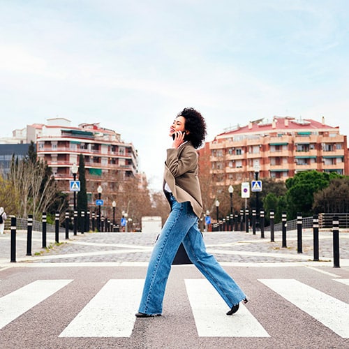 Efficience Consulting - Développement personnel. Photo d'une femme traversant une rue sur un passage piéton