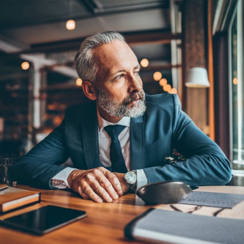 Efficience consulting - Le coaching individuel de cadres dirigeants et managers.Portrait d'un homme en costume d'une quarantaine d'année assis